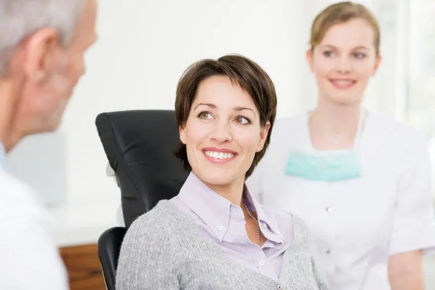 Smiling patient with dentist and nurse